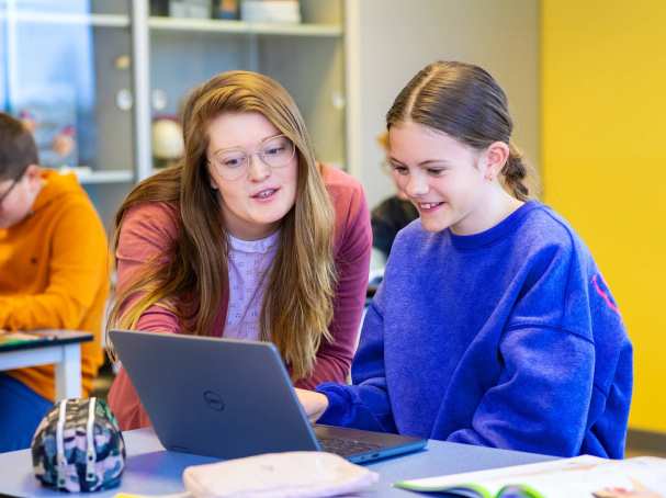 Fotoshoot op het Citadel 2024. De docente kijkt mee op het laptopscherm van een meisje in de klas. 