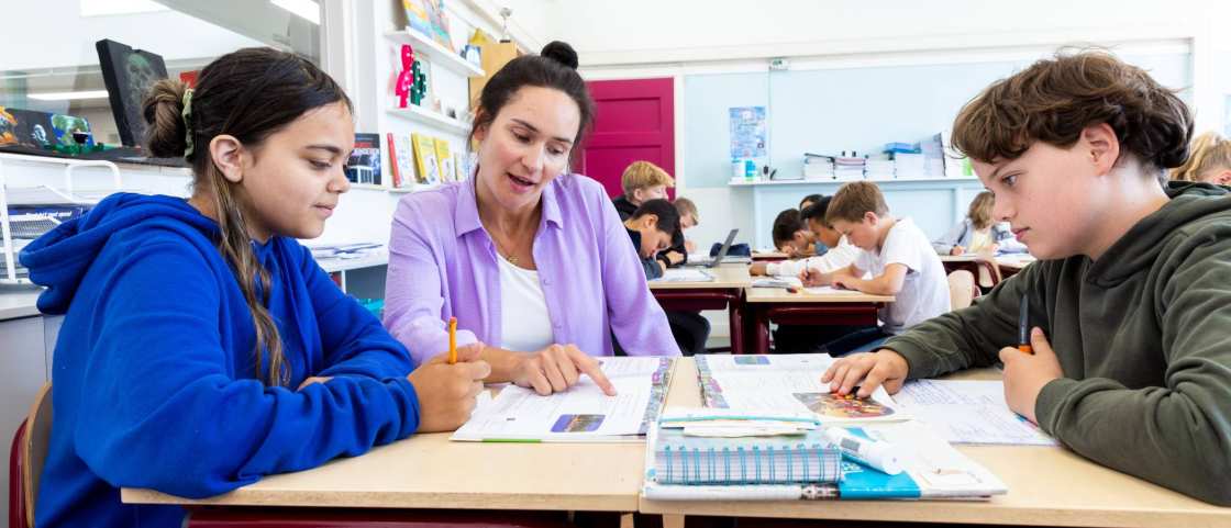 Docent Leonie van de opleiding leraar basisonderwijs aan tafel met leerlingen