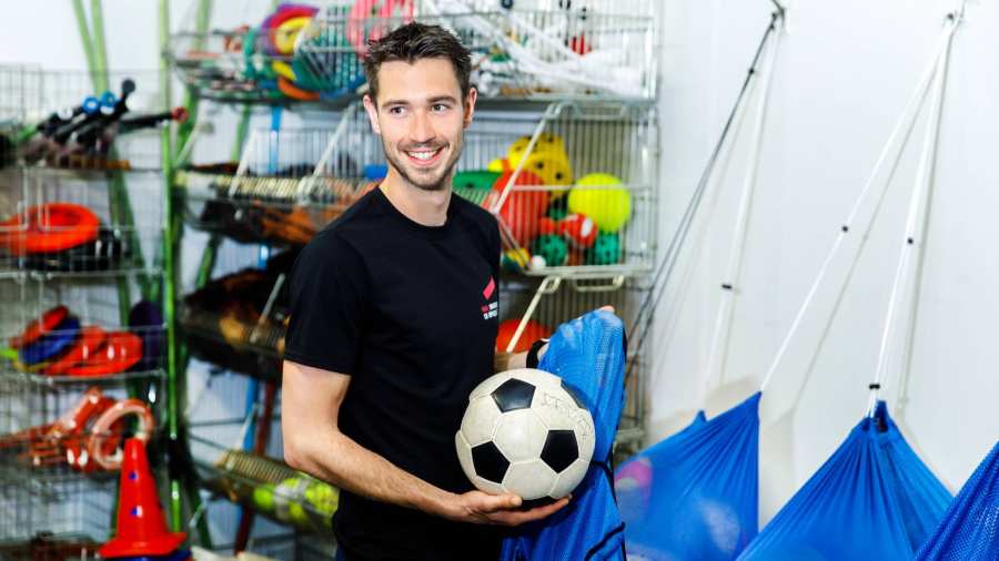 man in materiaal hok met voetbal