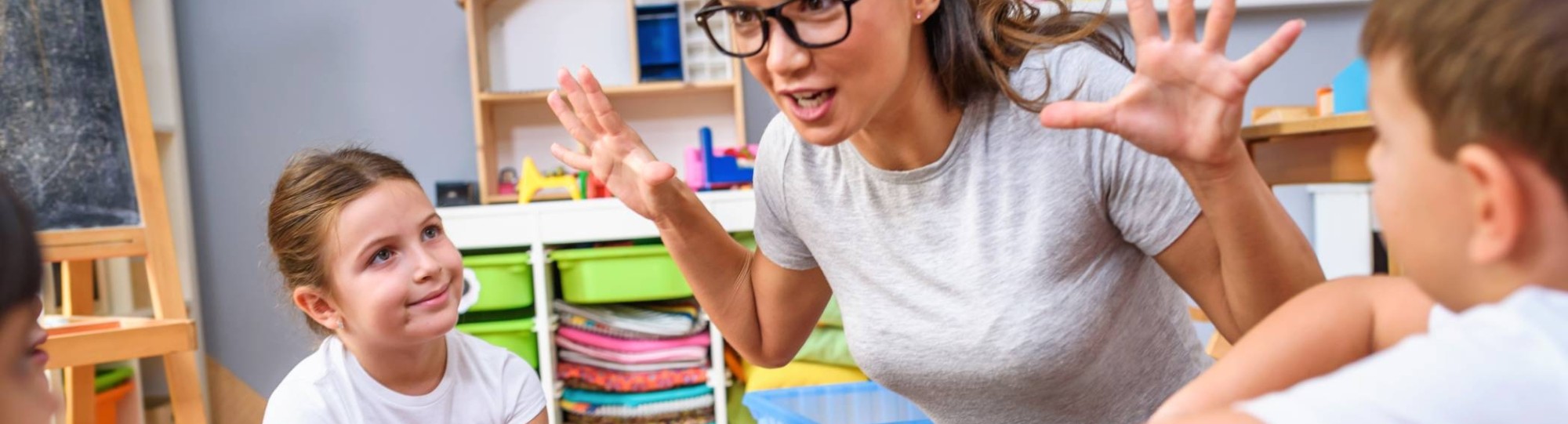 in gesprek met groep kinderen zittend in kleuterschoolÂ 