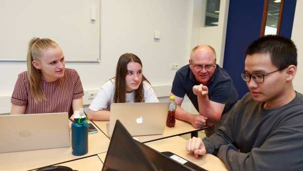 Docent Danial Godfrey en studenten Lisa Jansen, Nienke ten Cate en Dat Le van de voltijdopleiding Master Molecular Life Sciences overleggen tijdens een les