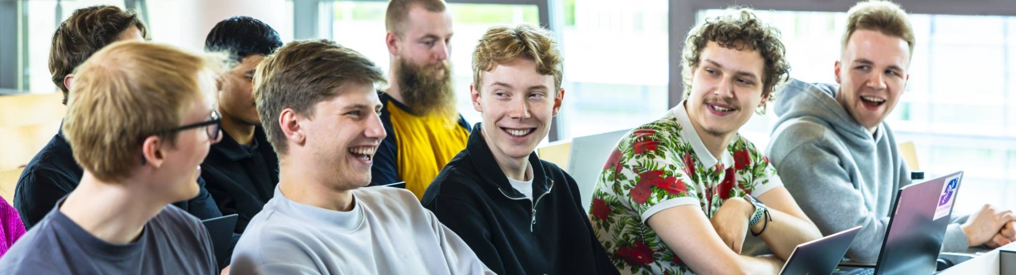 ICT-studenten lachen in een collegezaal