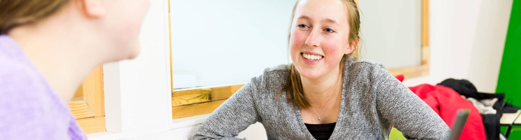 2 ALPO studenten kijken elkaar lachend aan