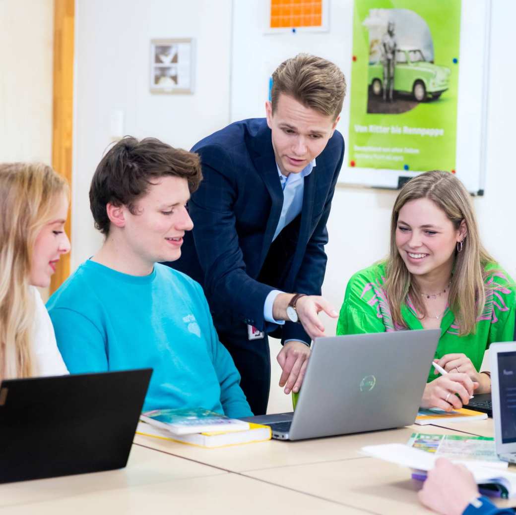 Twee studenten Leraar Nederlands bladeren door een boek in de mediatheek.