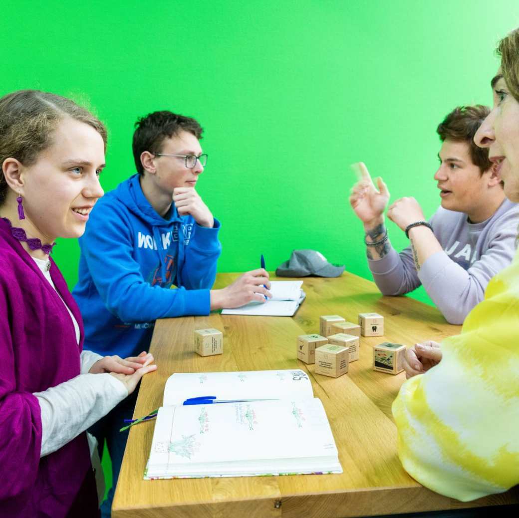 kinderen zitten rond tafel met blokken 