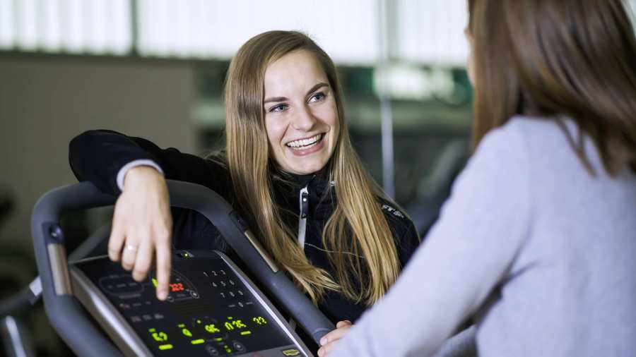 student geeft instructie bij crosstrainer