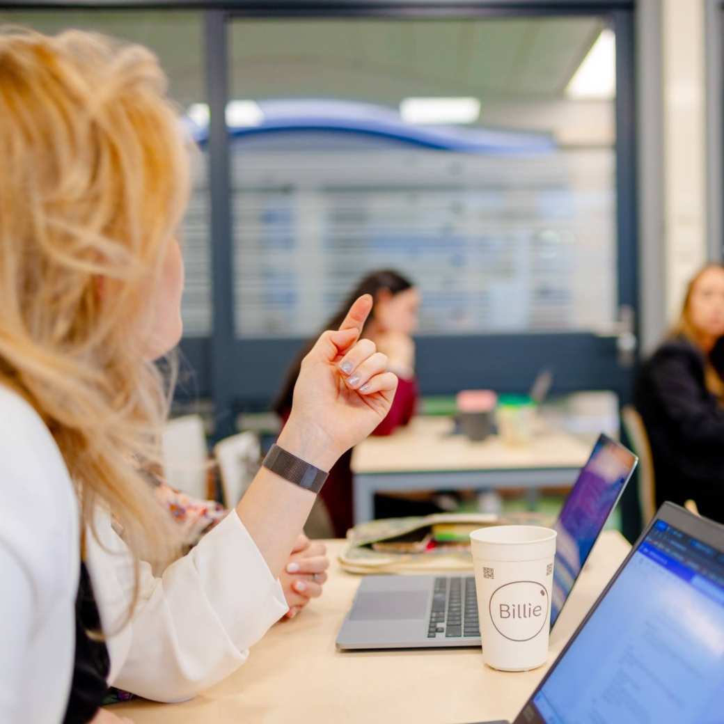 Duaal studenten van de associate degree Commerciële Economie in gesprek in klaslokaal.