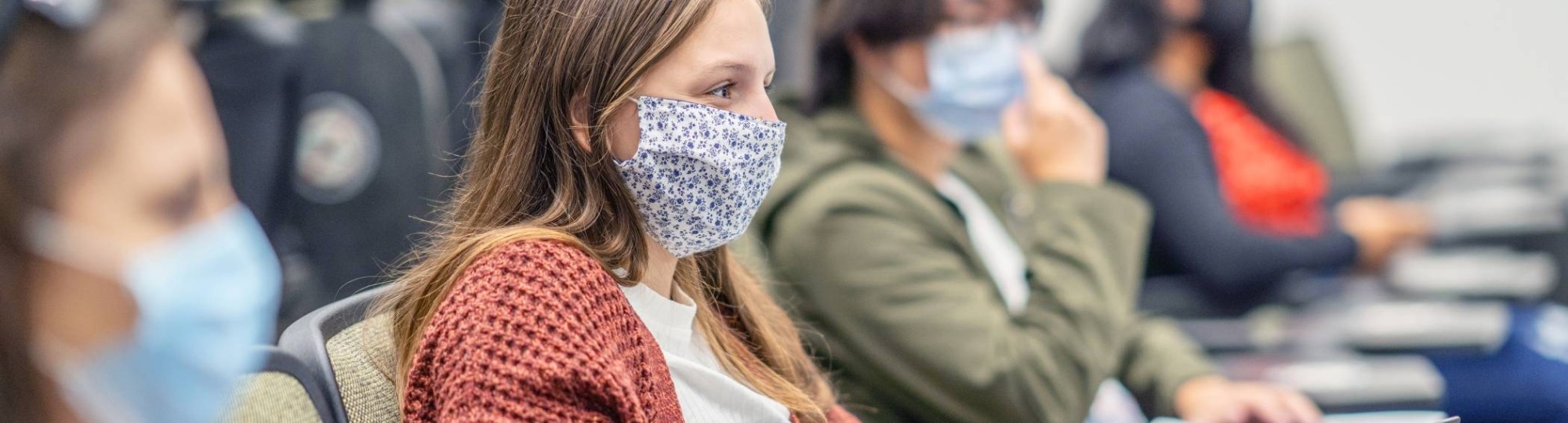 Studenten in collegezaal met mondkapjes op. Covid19. Corona