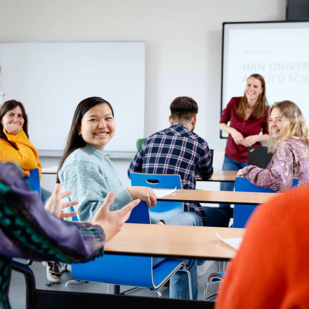 International students are listening and smiling in a classroom at HAN University of Applied Sciences