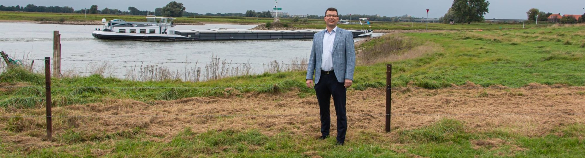 Promovendus Frank den Heijer in rivierenlandschap