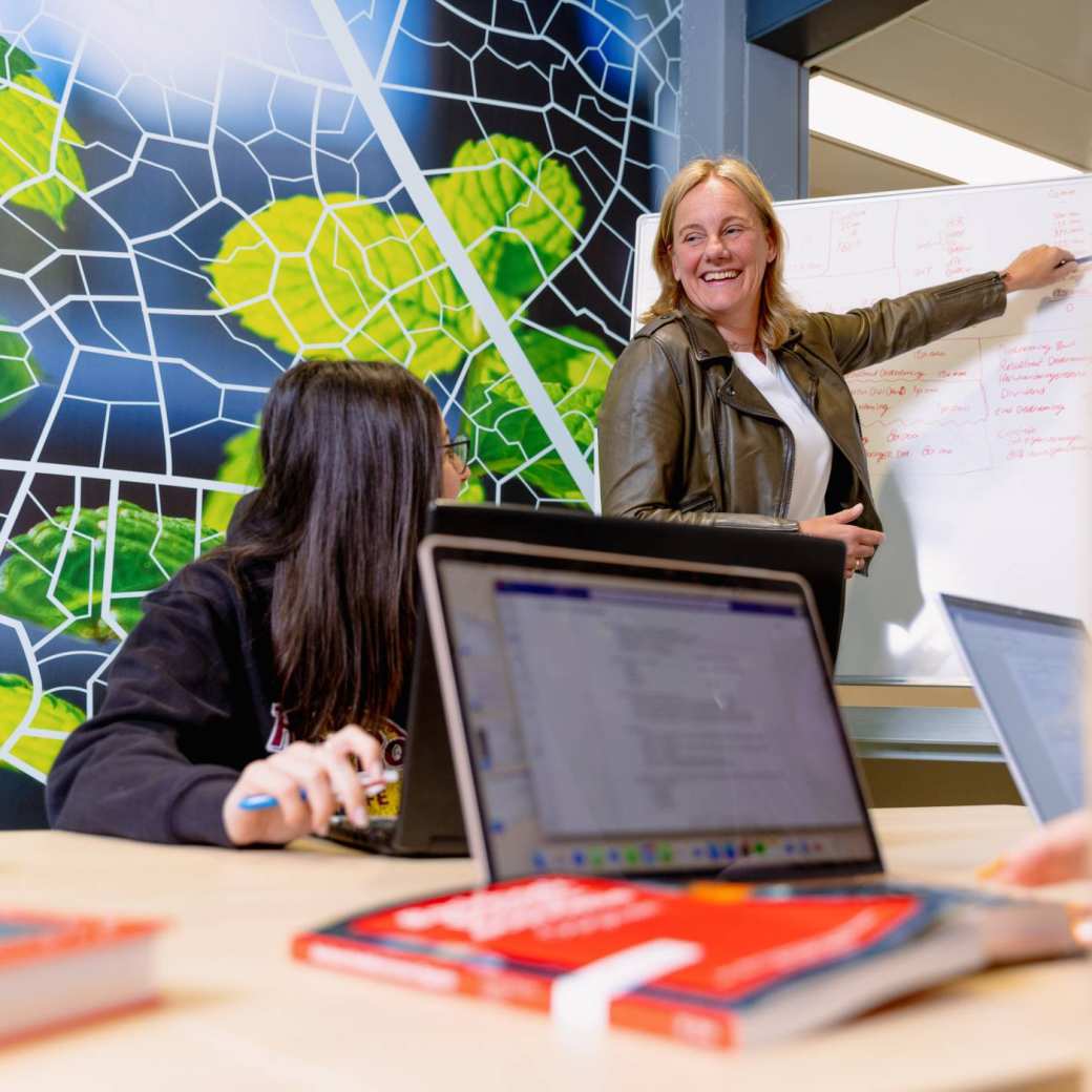 Docent uitleg tijdens een projectbijeenkomst met Finance & Control studenten