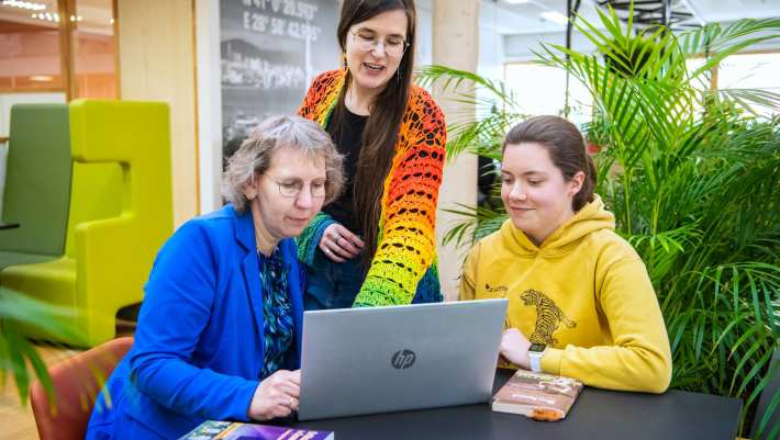 Foto Master Academie Educatie. 3 masterstudenten werken samen en kijken op een laptop. 