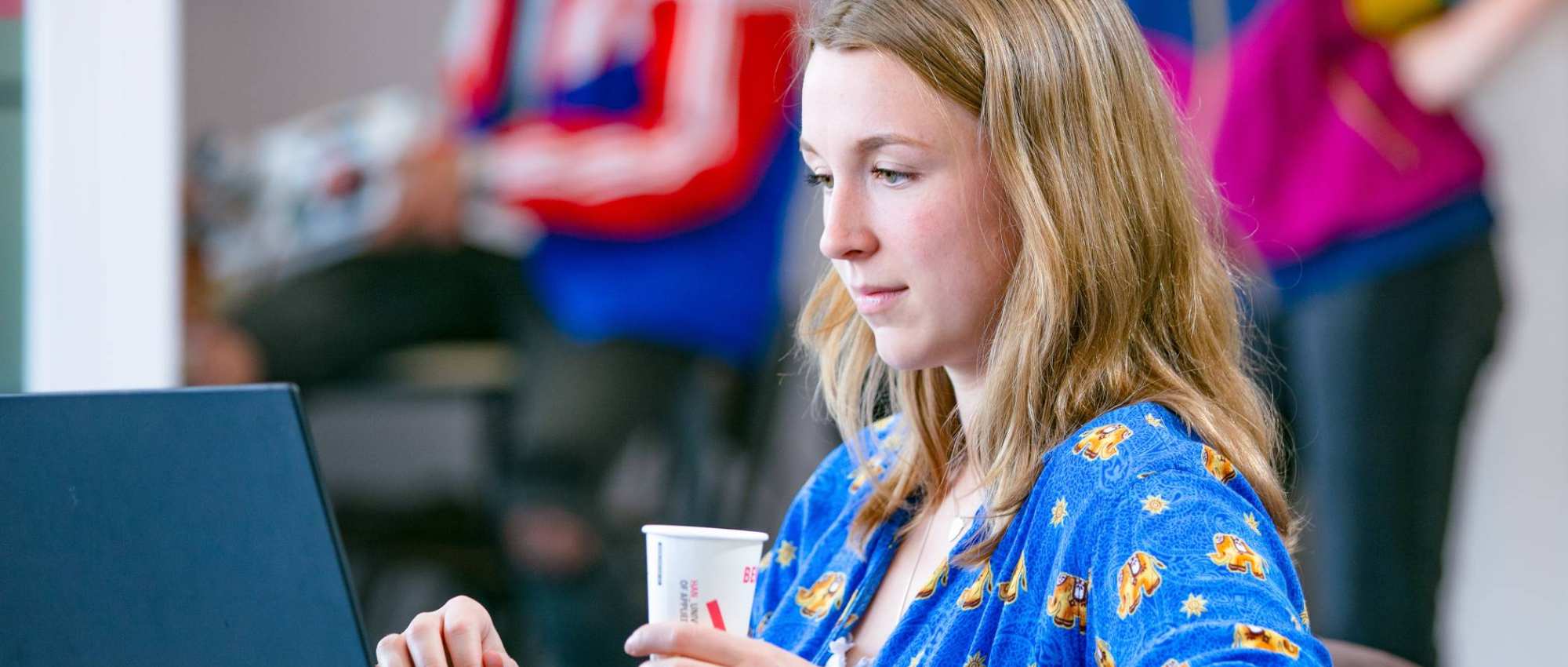 Student aan het werk/leren op laptop met koffie