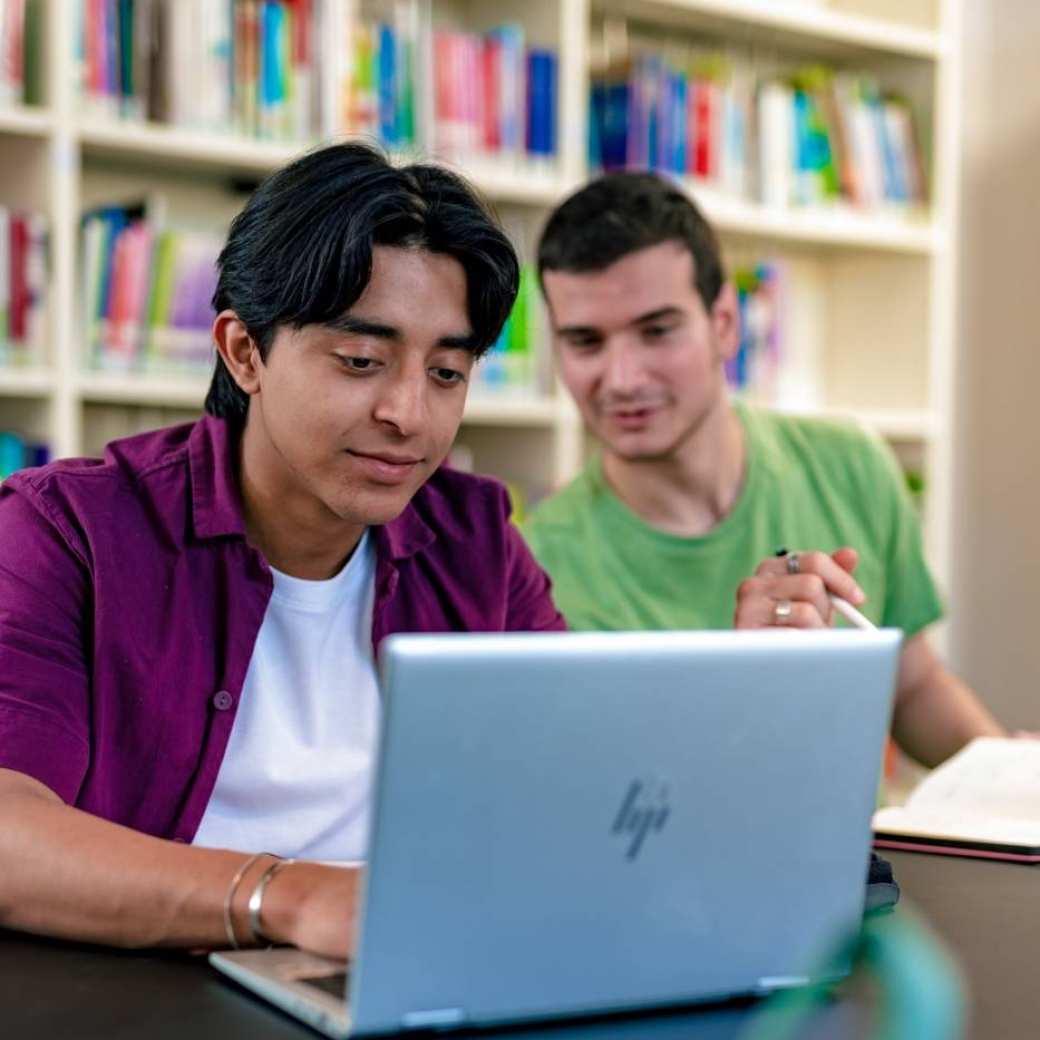 Studenten vragen de tegemoetkoming studievoucher aan op een laptop.