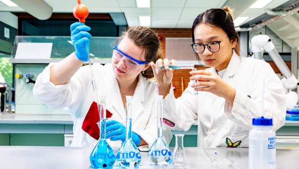 studenten pipetteren in het chemielab