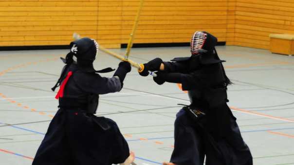 2 jongens uit Kazakhstan beoefenen in zwarte gewaden hun vechtsport.