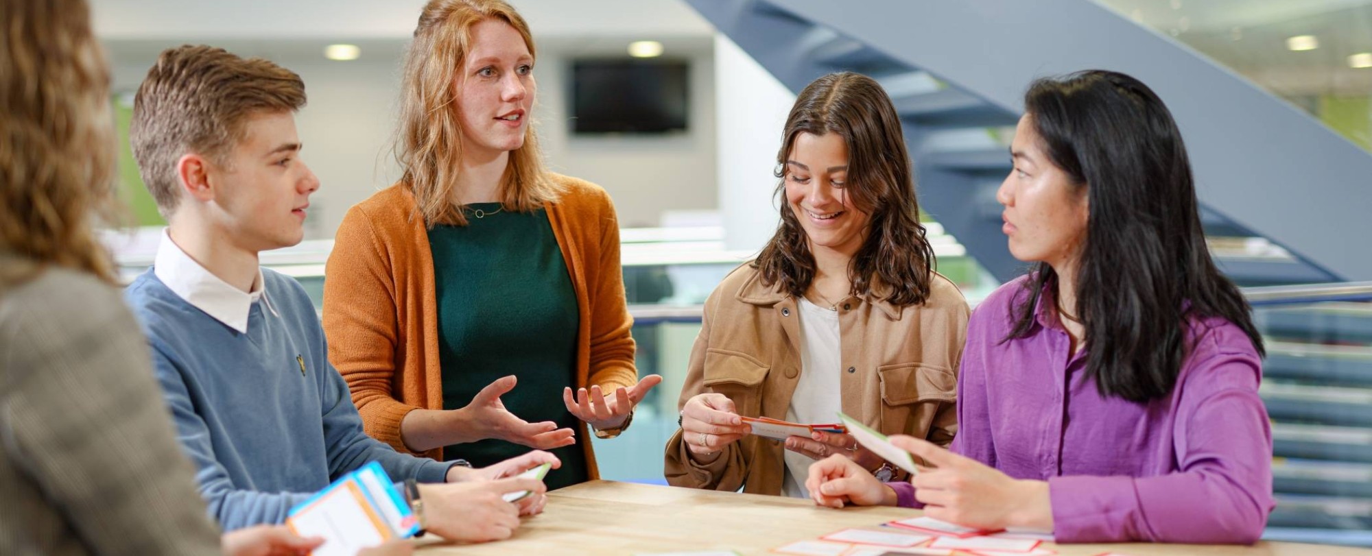 studenten en docent van de opleiding toegepaste psychologie spelen een kaartspel