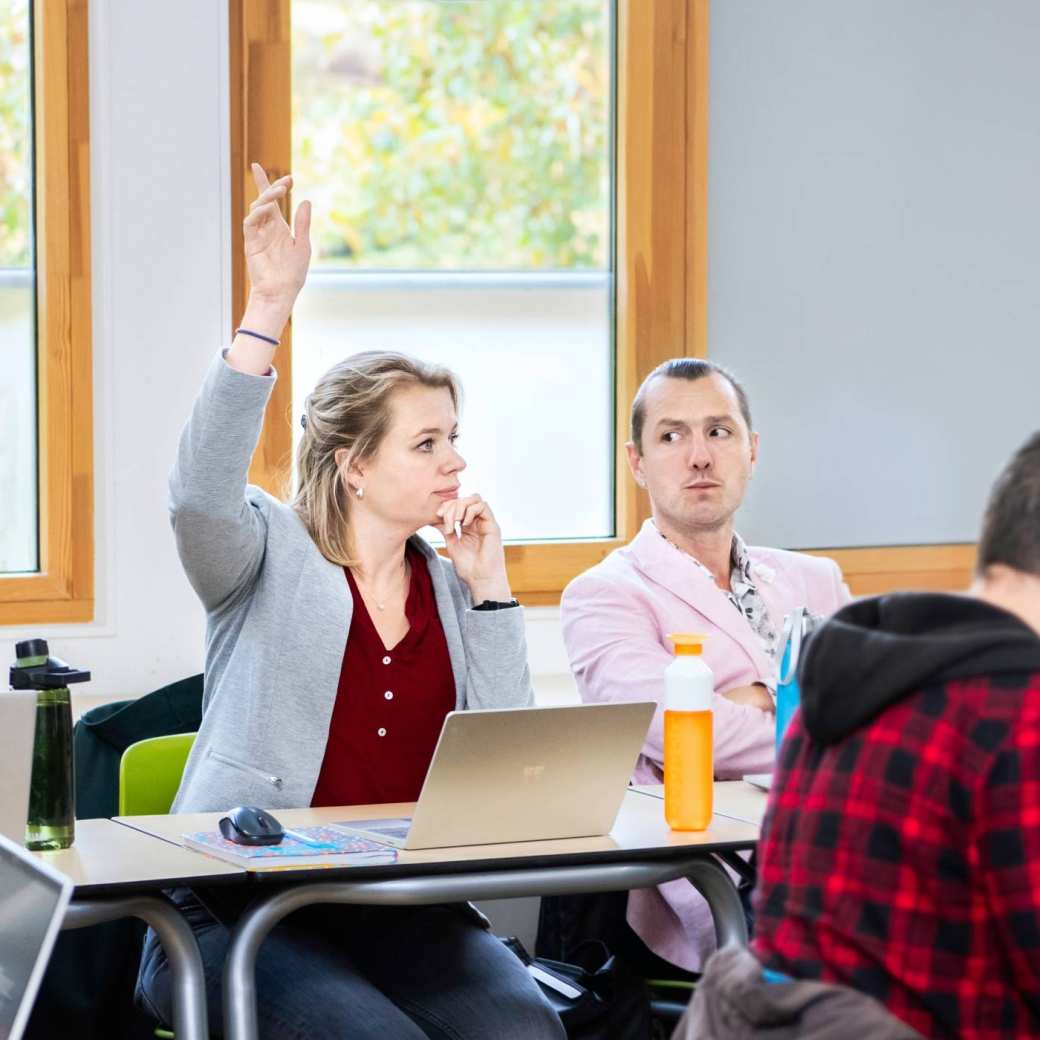 masterstudent in de klas met de vinger omhoog