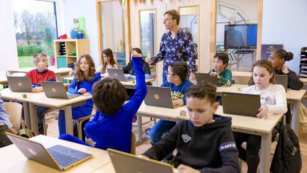 Docent staat in de klas bij groep 6 en geeft een klassikale instructie