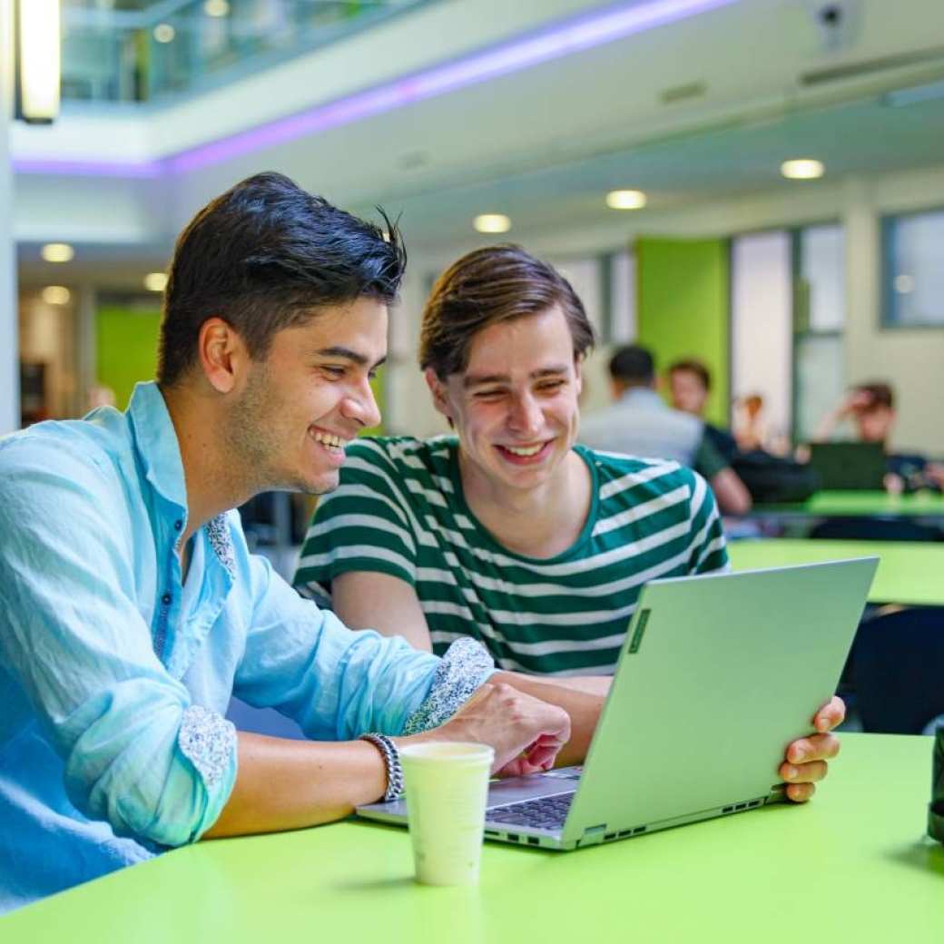 twee personen van bedrijfskunde kijkende naar een laptop