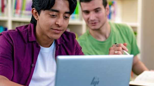 2 studenten International Social Work zitten achter de laptop.