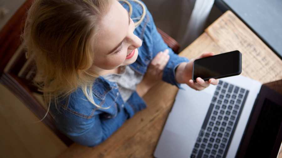 Stockfoto van vrouw met laptop en telefoon voor website Centrum Meervoudige Waardecreatie. 