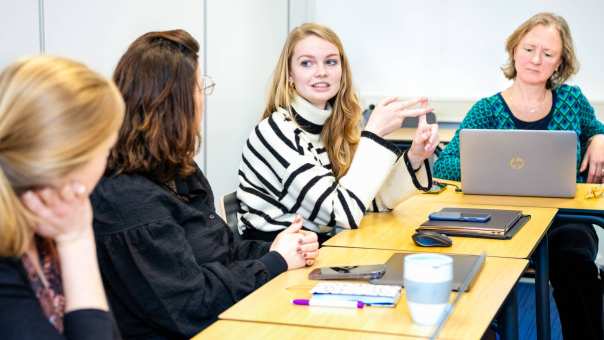 Een aantal studenten overleggen met elkaar tijdens lessituatie