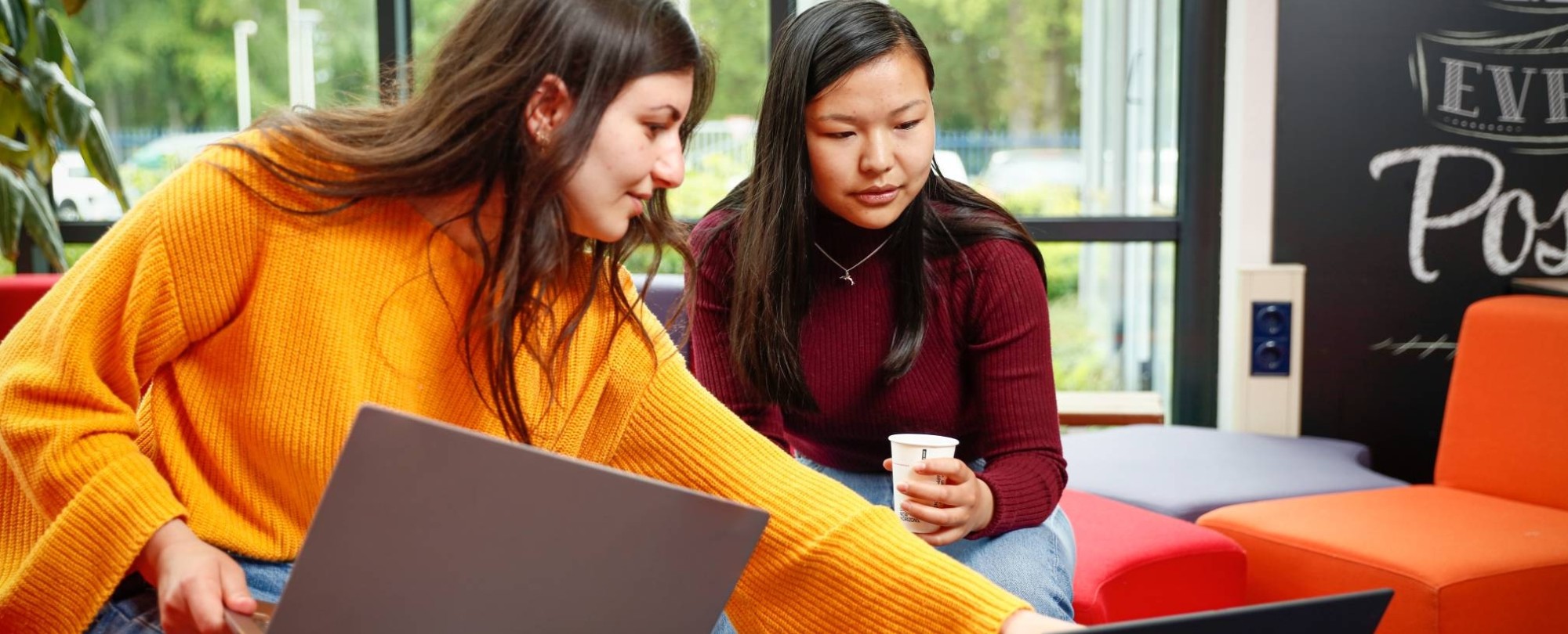 Twee studenten met laptop overleggen en wijst naar scherm