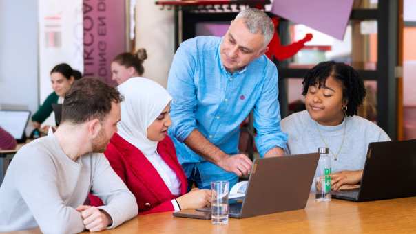 Docent geeft groepje studenten uitleg