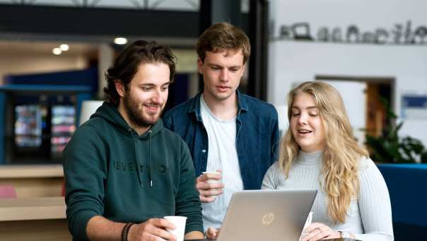 Studenten bekijken studiemateriaal op hun laptop tijdens een pauze op de HAN